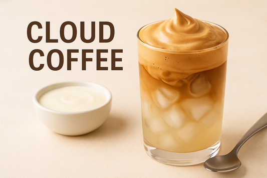 A glass of cloud coffee topped with rich espresso foam over ice, next to a bowl of cream and a spoon on a beige background with “Cloud Coffee” in bold text.