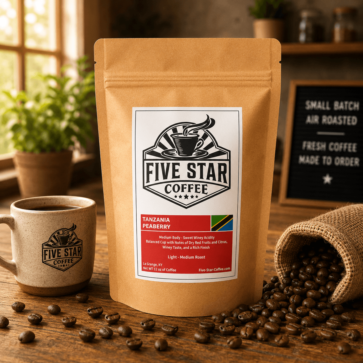 Five Star Coffee Tanzania Peaberry coffee bag on a warm wooden table with coffee beans, featuring a light-medium roast with sweet winey acidity, dry red fruit, citrus, and a rich finish.